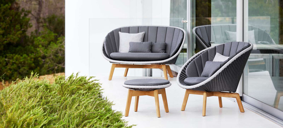 Peacock Upholstery Footstool by Cane-Line, showing peacock upholstery footstool in live shot.