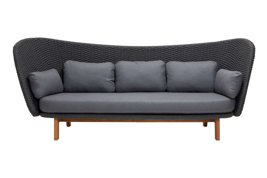 Peacock Wing 3 Seater Sofa with Teak Legs by Cane-Line, showing front view of peacock wing 3 seater sofa with teak legs in dark grey soft rope/grey natte cushions.