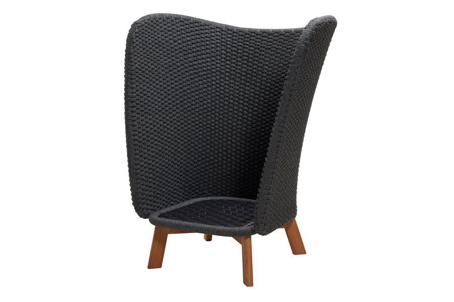 Peacock Wing Highback Chair with Teak Legs by Cane-Line, showing angle view of peacock wing highback chair without cushion in teak/dark grey soft rope.