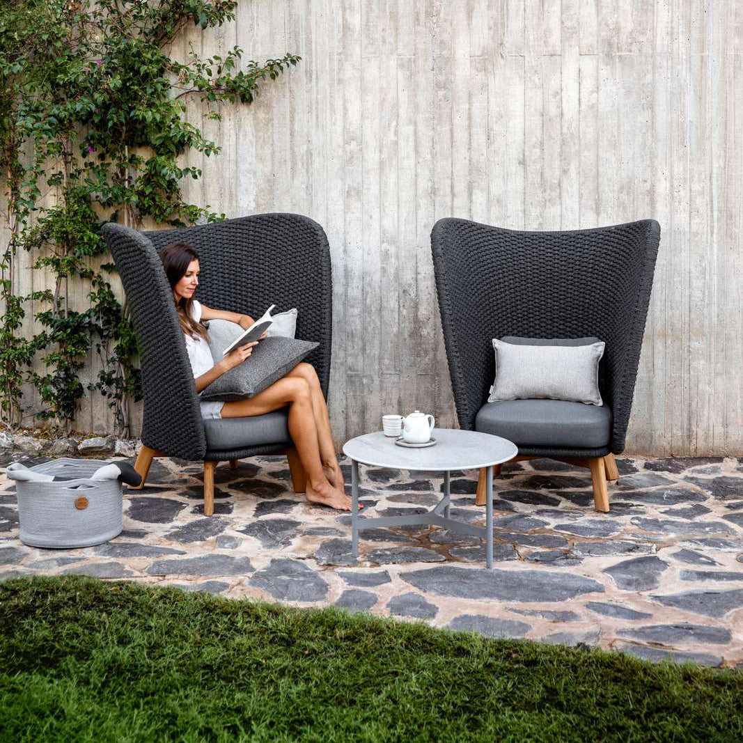 Peacock Wing Highback Chair with Teak Legs by Cane-Line, showing two peacock wing highback chairs in live shot.