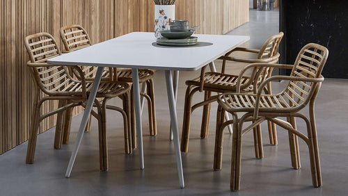 Peak Rattan Dining Armchair by Cane-Line, showing peak rattan dining armchairs with table in live shot.