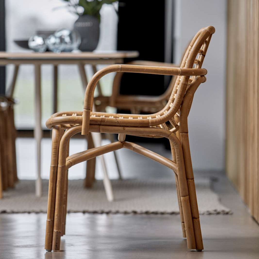 Peak Rattan Dining Armchair by Cane-Line, showing peak rattan dining armchairs with table in live shot.