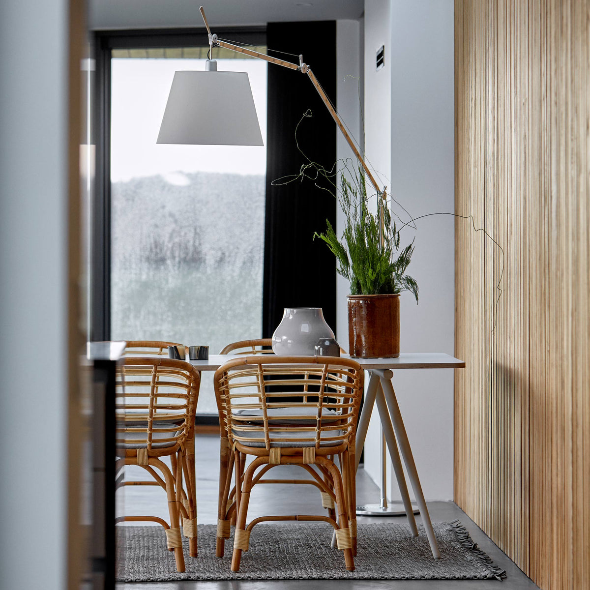Peak Rattan Dining Chair by Cane-Line, showing peak rattan dining chairs with table in live shot.