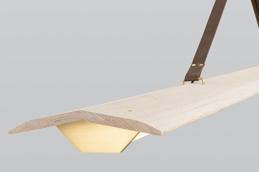 Penna 64" LED Pendant by Cerno, showing closeup view of penna 64" led pendant in brushed brass metal + white washed oak wood.
