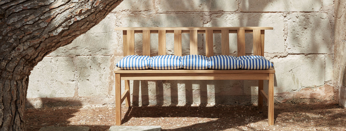 Plank Bench 144 by Skagerak, showing plank bench 144 with cushion in live shot.