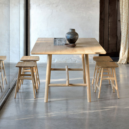 Profile Dining Table by Ethnicraft, shoiwng side view of dining table with chairs in the live shot.
