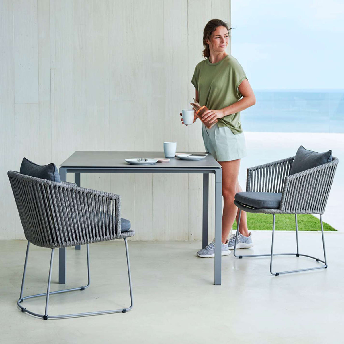 Pure Aluminum Square Dining Table by Cane-Line, showing pure aluminum square dining table with chairs in live shot.