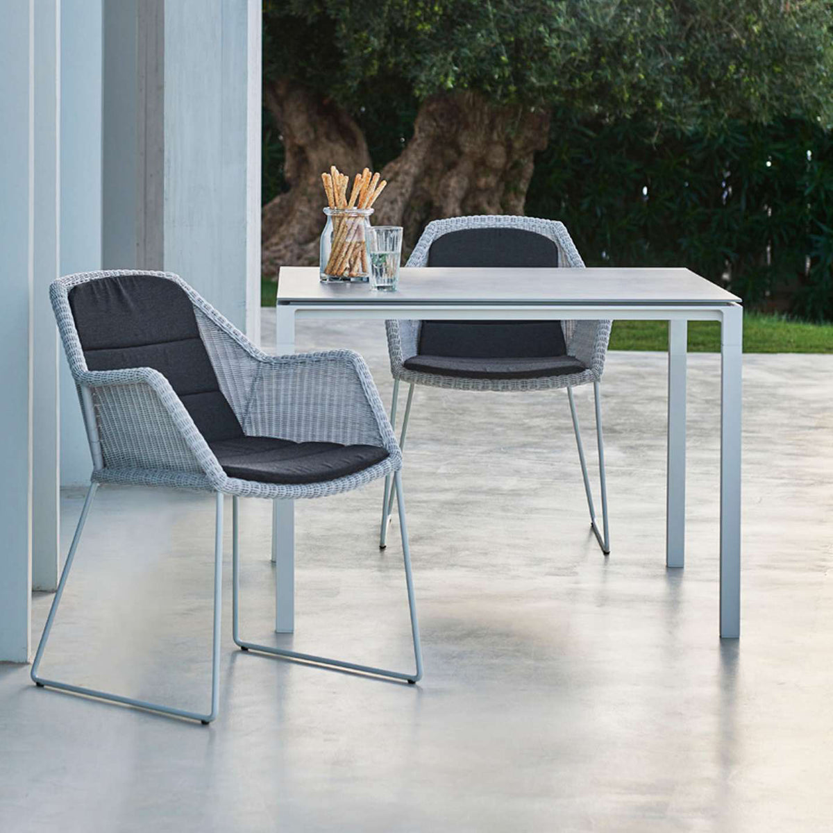Pure Aluminum Square Dining Table by Cane-Line, showing pure aluminum square dining table with chairs in live shot.