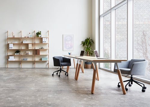 Radius Chair by Gus Modern, showing radius chairs with tables & shelve in live shot.