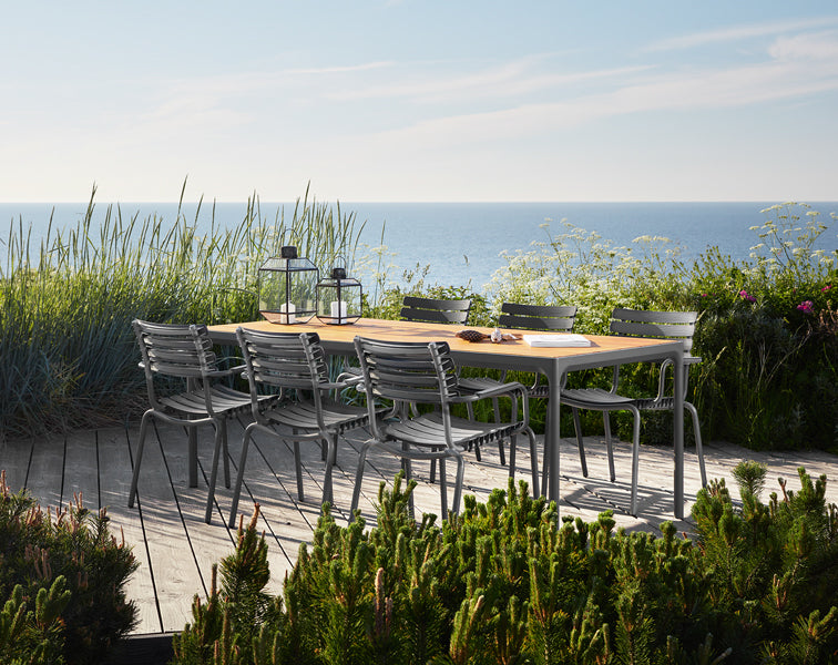 Reclips Outdoor Dining Chair by Houe, showing reclips outdoor dining chairs with table in live shot.