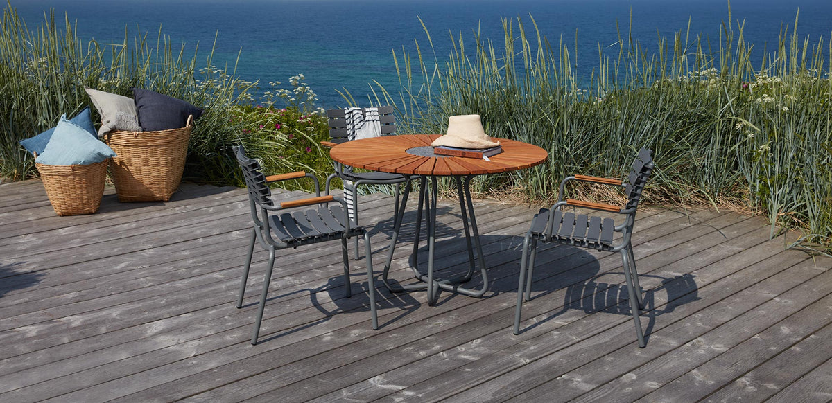 Reclips Outdoor Dining Chair by Houe, showing reclips outdoor dining chairs with table in live shot.