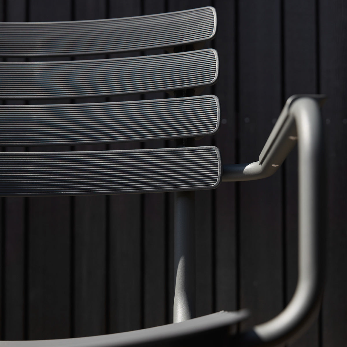 Reclips Outdoor Dining Chair by Houe, showing closeup view of reclips outdoor dining chair in live shot.