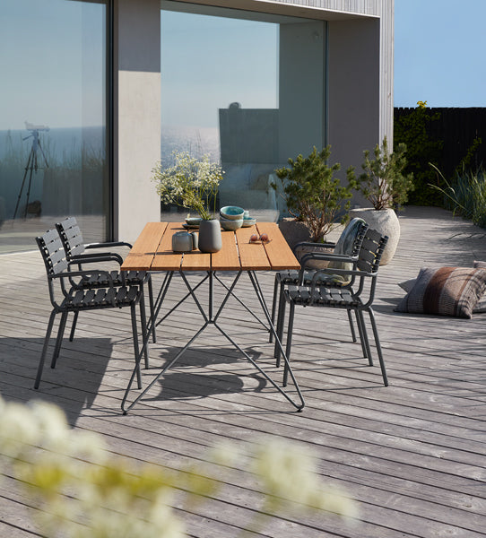 Reclips Outdoor Dining Chair by Houe, showing reclips outdoor dining chairs with table in live shot.