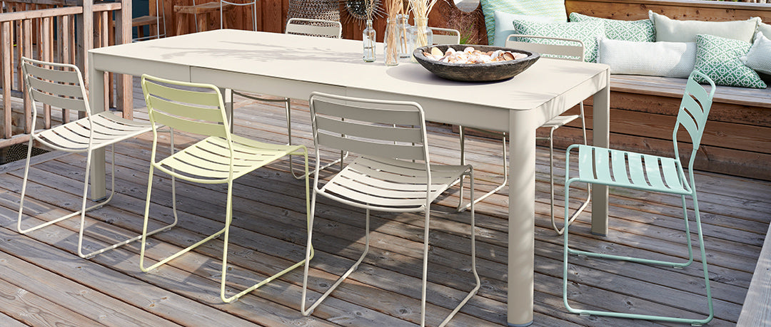 Ribambelle Extension Tables by Fermob, showing ribambelle extension tables with chairs in live shot.