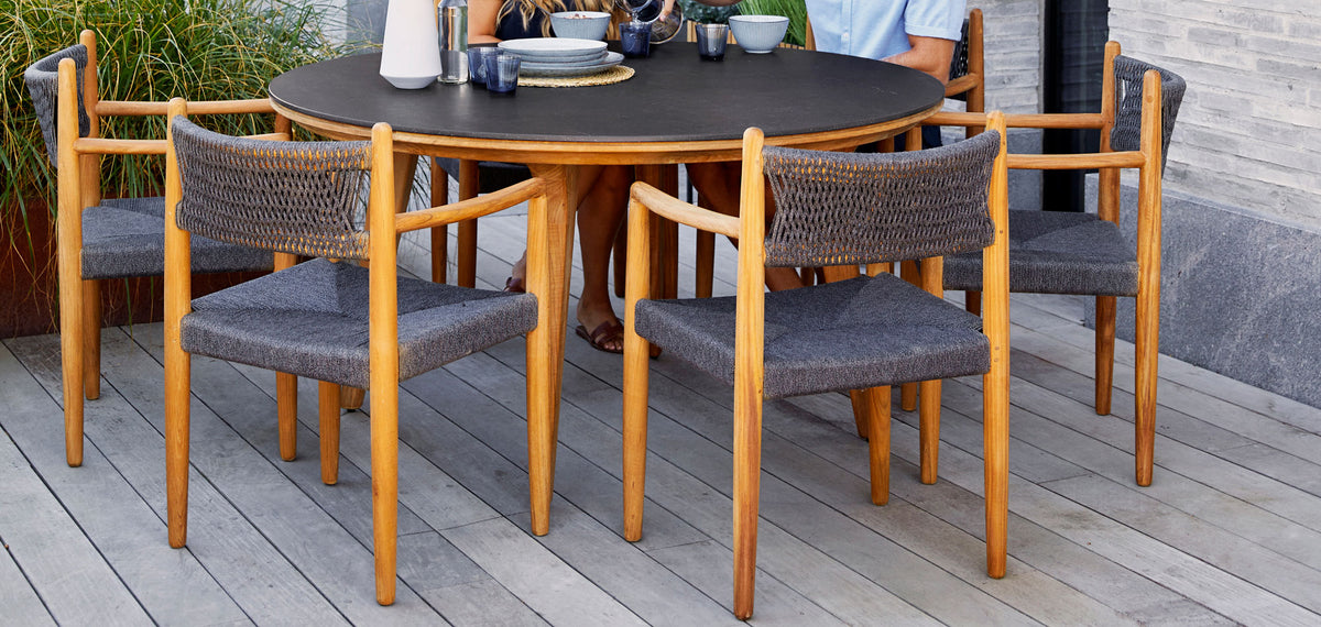 Royal Outdoor Dining Armchair by Cane-Line, showing royal outdoor dining armchairs with table in live shot.