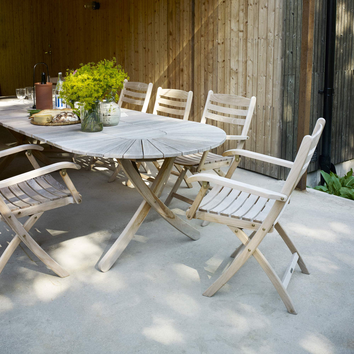 Selandia Extendable Table by Skagerak, showing selandia extendable table with chairs in live shot.