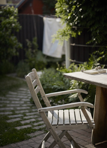 Selandia Teak Armchair by Skagerak, showing selandia teak armchair with table in live shot.