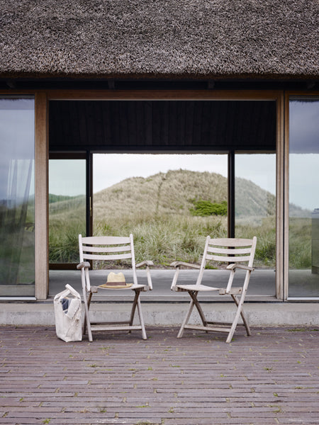 Selandia Teak Armchair by Skagerak, showing selandia teak armchairs in live shot.