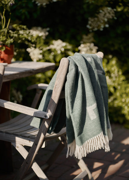 Selandia Teak Armchair by Skagerak, showing selandia teak armchair in live shot.
