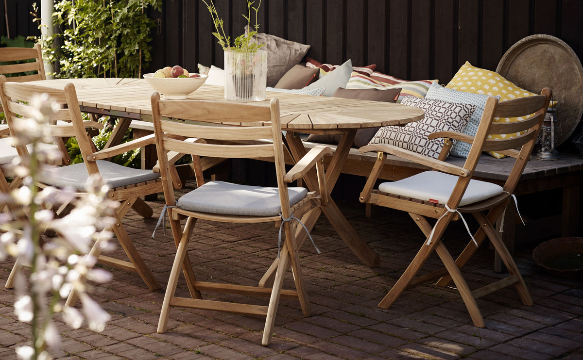 Selandia Teak Armchair by Skagerak, showing selandia teak armchairs with table in live shot.