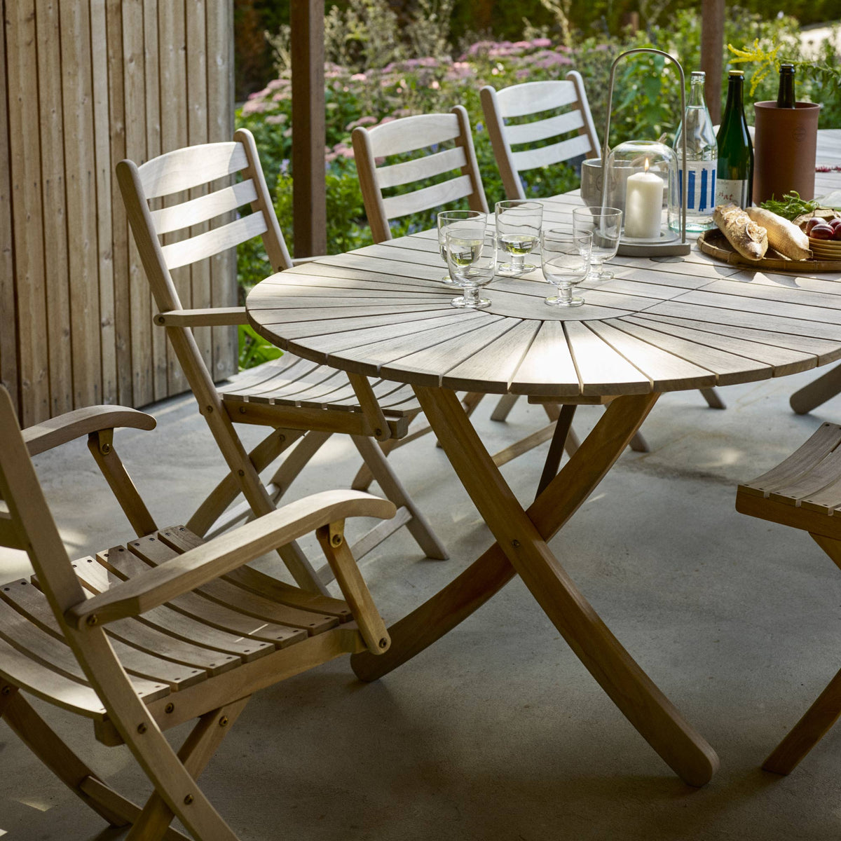 Selandia Teak Armchair by Skagerak, showing selandia teak armchairs with table in live shot.