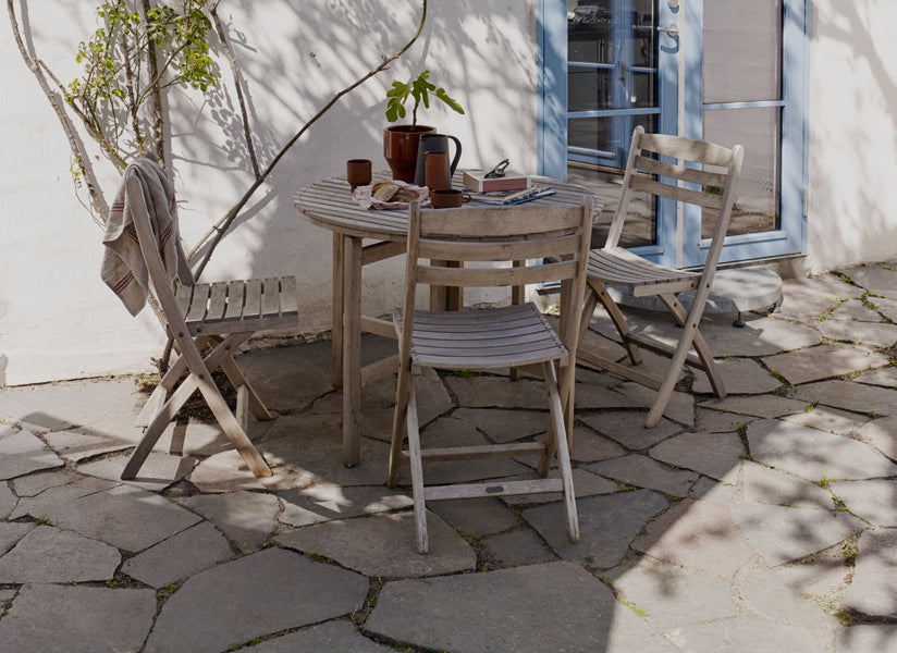 Selandia Teak Chair by Skagerak, showing selandia teak chairs with table in live shot.