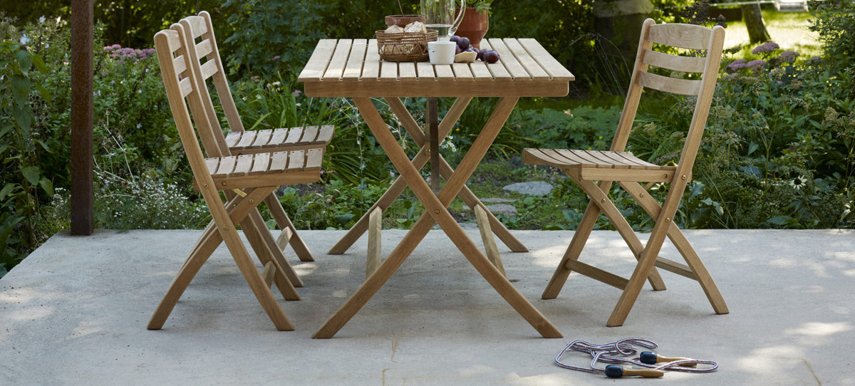 Selandia Teak Chair by Skagerak, showing selandia teak chairs with table in live shot.