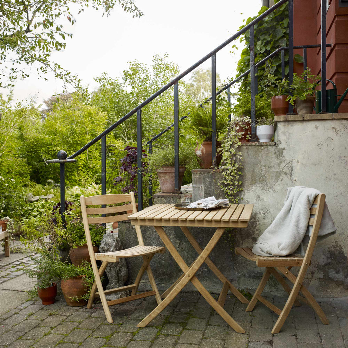Selandia Teak Chair by Skagerak, showing selandia teak chairs with table in live shot.