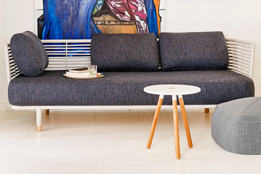 Sense Indoor 3-seater Sofa by Cane-Line, showing sense indoor 3-seater sofa with table in live shot.