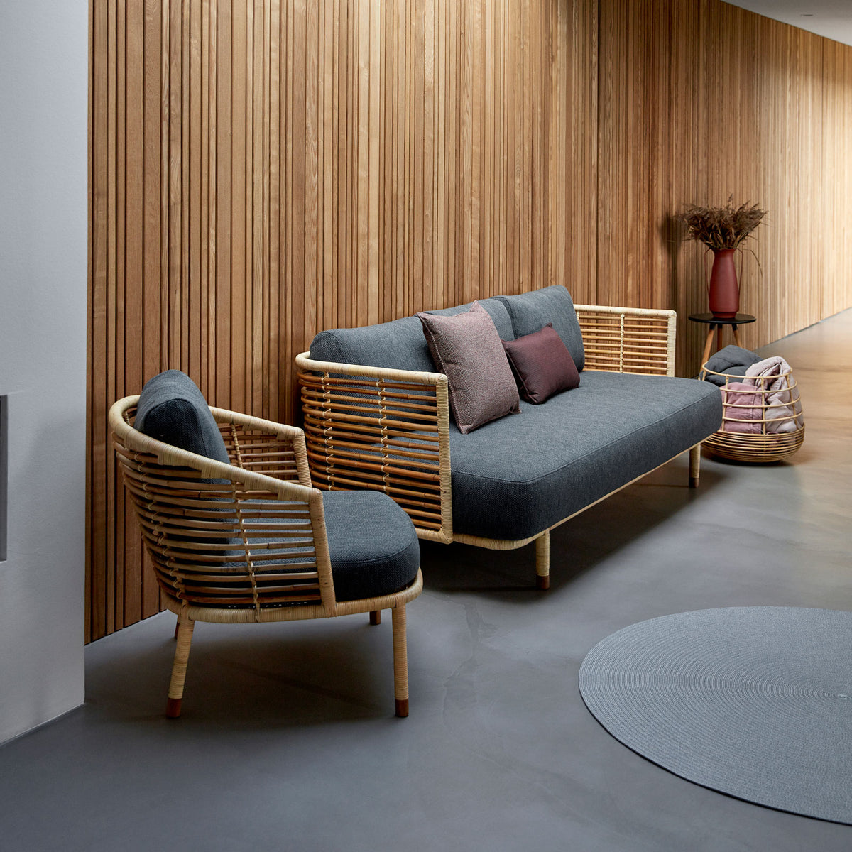 Sense Indoor 3-seater Sofa by Cane-Line, showing sense indoor 3-seater sofa with chair in live shot.