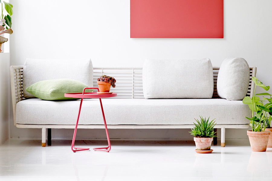 Sense Indoor 3-seater Sofa by Cane-Line, showing sense indoor 3-seater sofa with table in live shot.