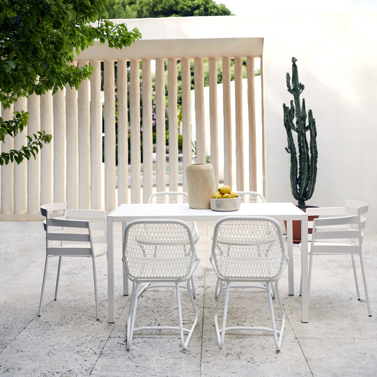 Sixties Side Chair by Fermob, showing back view of side chair with dining table in the live shot.