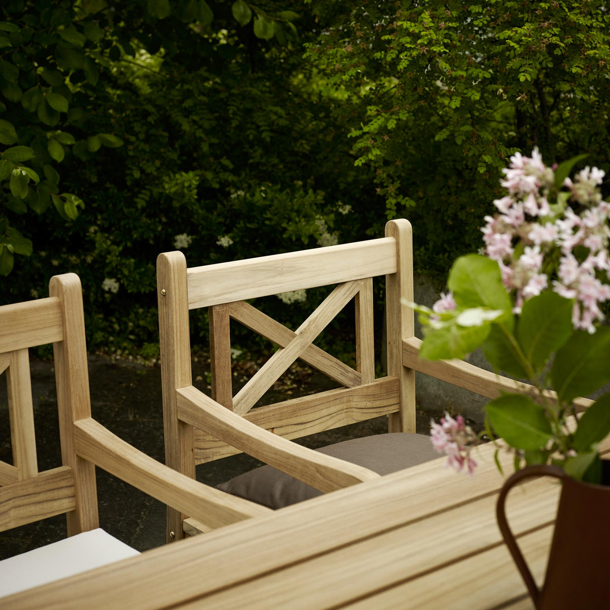 Skagen Chair by Skagerak, showing closeup view of skagen chairs with table in live shot.