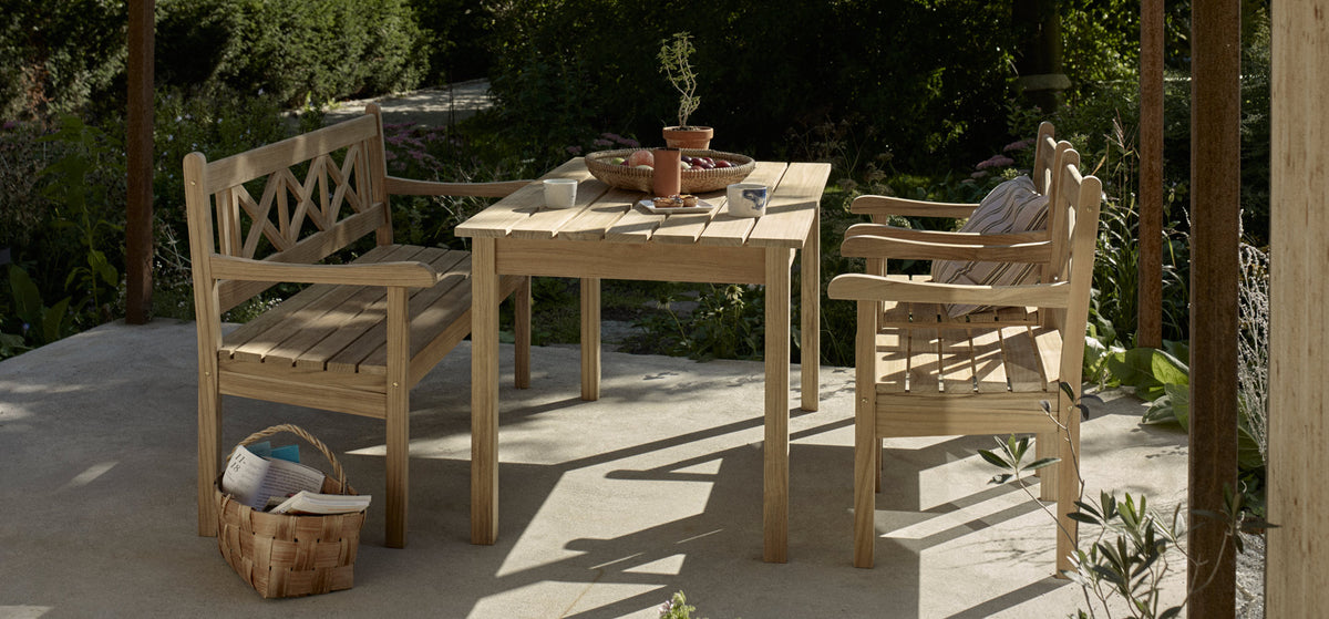 Skagen Table by Skagerak, showing skagen table with chairs & bench in live shot.