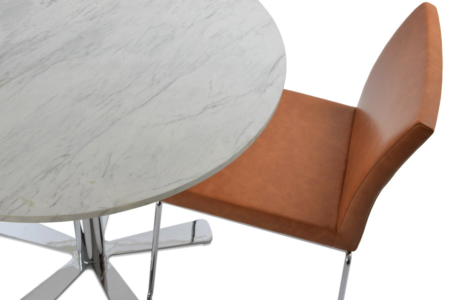 Aria Stackable Dining Chair by sohoConcept, showing closeup view of caramel ppm with chrome base & daisy marble dining table.