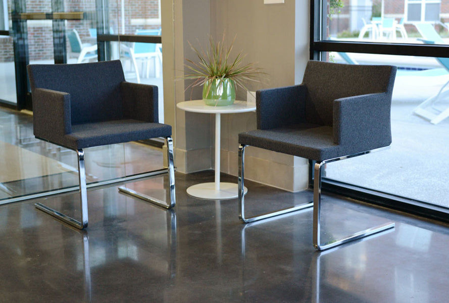 Soho Flat Lounge Arm Chair by SohoConcept, showing flat lounge arm chairs with table in live shot.