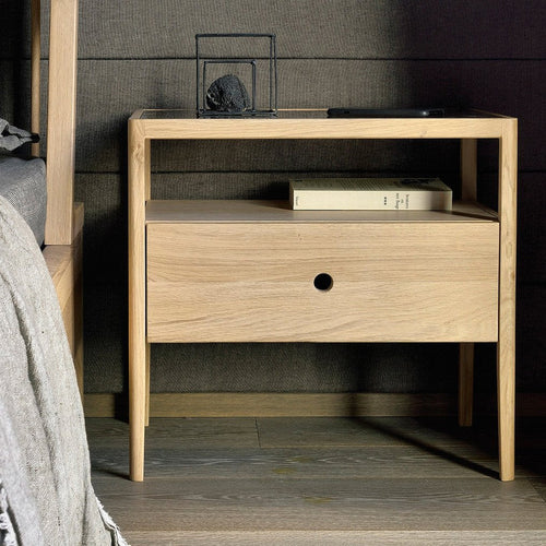 Spindle Bedside Table by Ethnicraft, showing closeup view of spindle bedside table with bed in live shot.