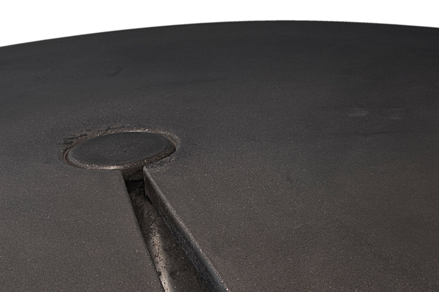 James De Wulf Split Locking Round Dining Table by De Wulf, showing closeup view of split locking round dining table in dark grey concrete.
