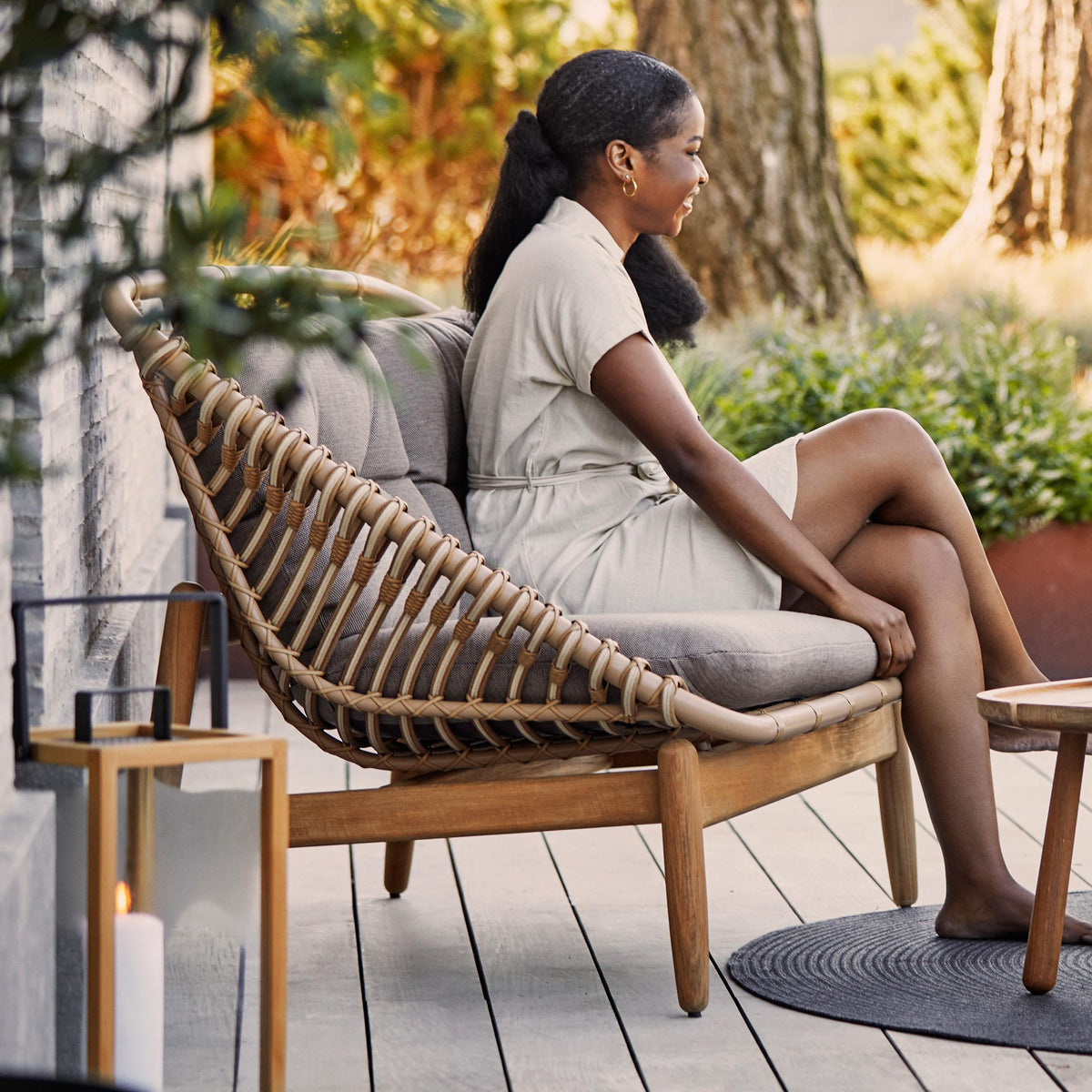 Strington Outdoor Teak 2-Seater Sofa by Cane-Line, showing strington outdoor teak 2-seater sofa with table in live shot.