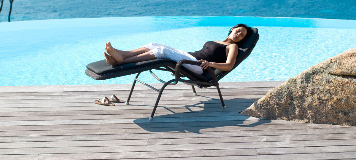 Sunrise Stackable Relaxing Chair by Cane-Line, showing sunrise stackable relaxing chair in live shot.