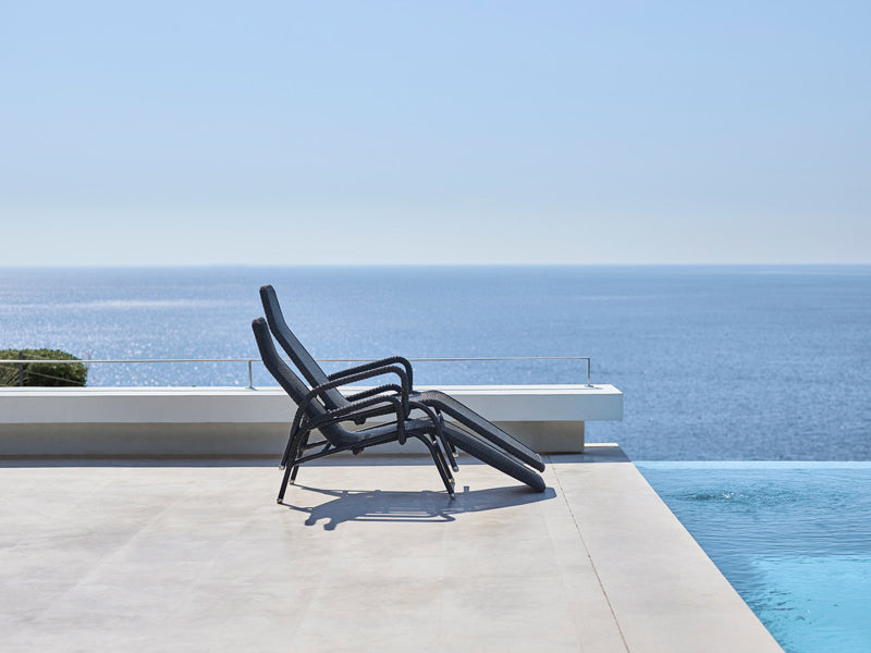 Sunrise Stackable Relaxing Chair by Cane-Line, showing sunrise stackable relaxing chairs in live shot.