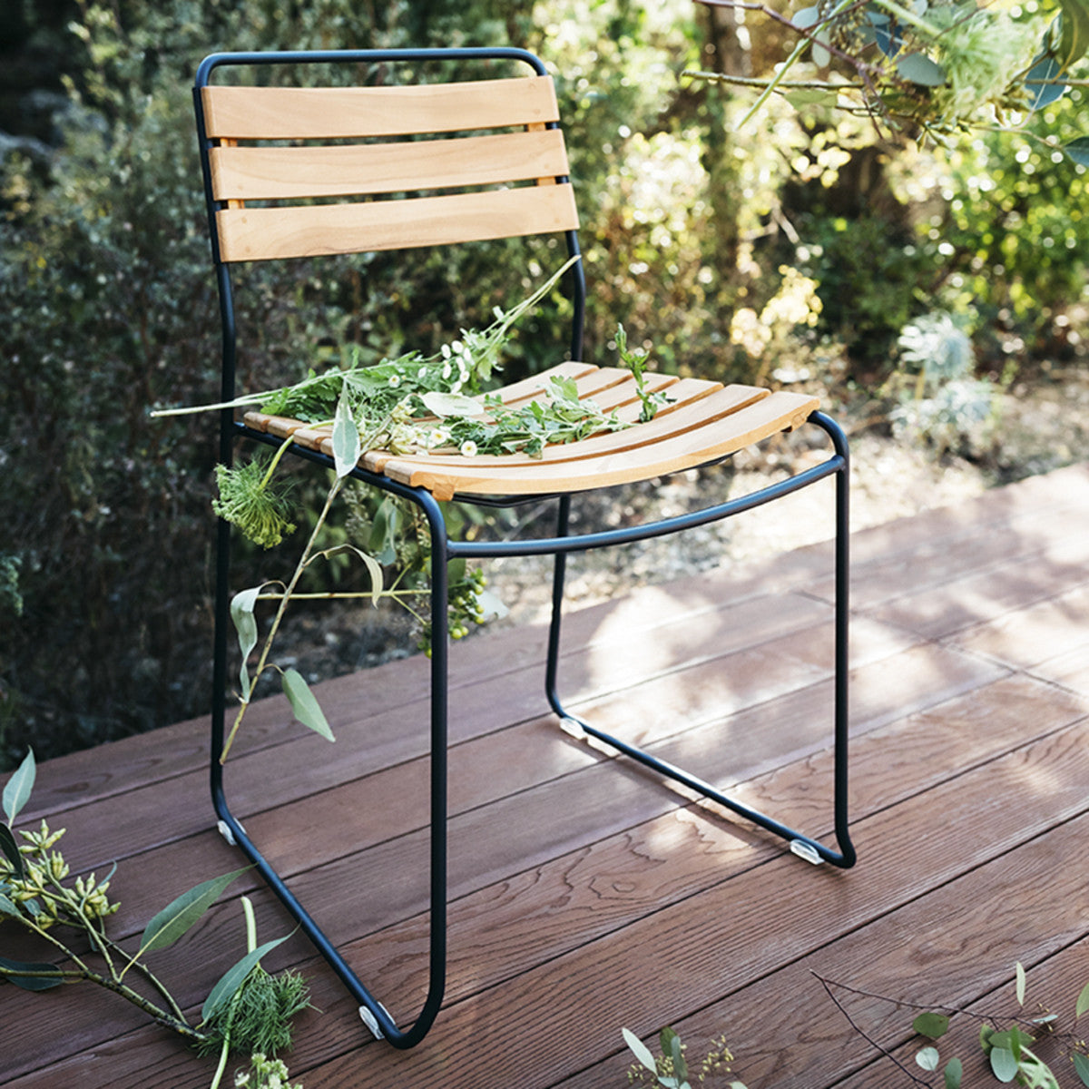 Surprising Teak Chair by Fermob, showing angle view of chair in the live shot.