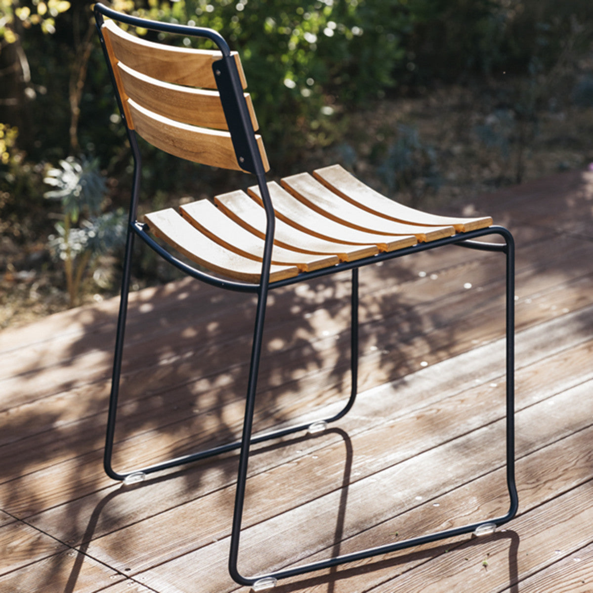 Surprising Teak Chair by Fermob, showing angle view of chair in the live shot.