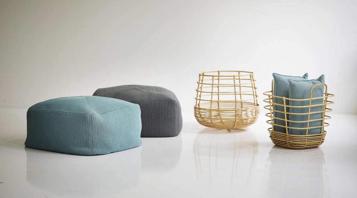 Sweep Rattan Basket by Cane-Line, showing sweep rattan baskets with ottomans in live shot.