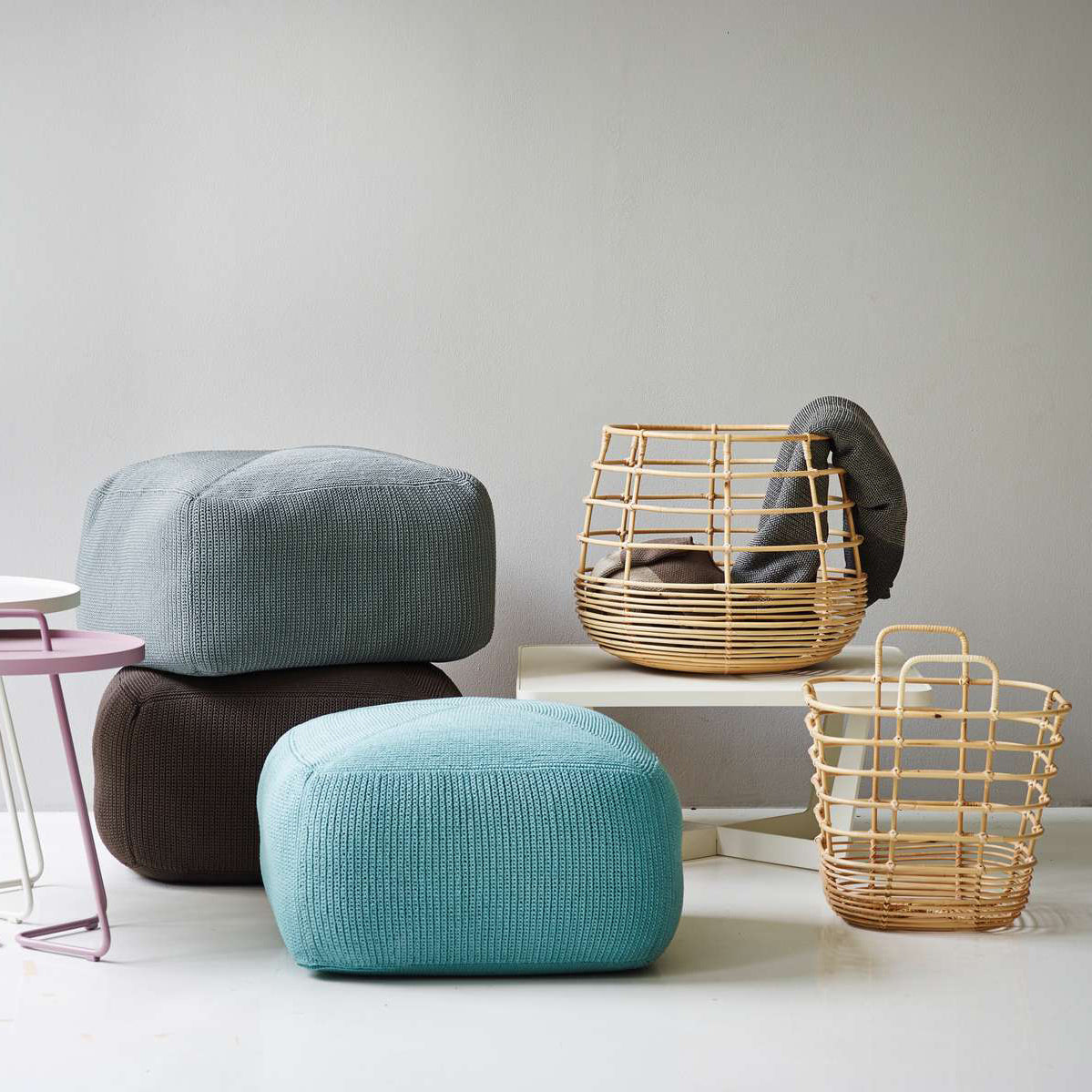 Sweep Rattan Basket by Cane-Line, showing sweep rattan baskets with ottomans, tables in live shot.