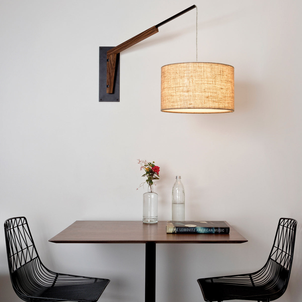 Talea Sconce by Cerno, showing talea sconce with table & chairs in live shot.