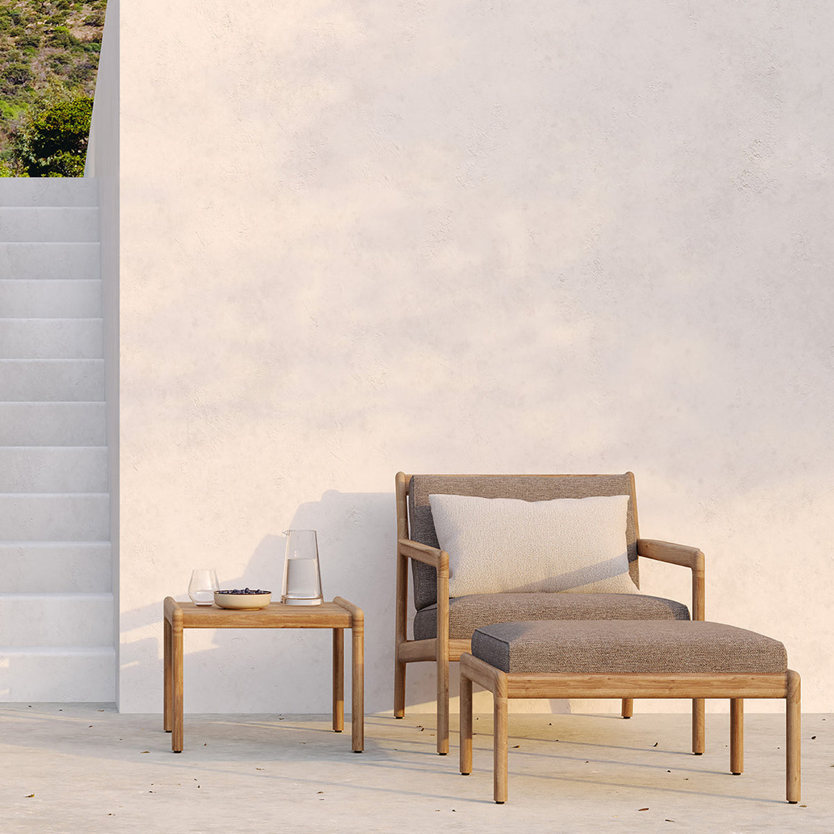 Jack Outdoor Footstool by Ethnicraft, showing front view of footstool with chair in the live shot.