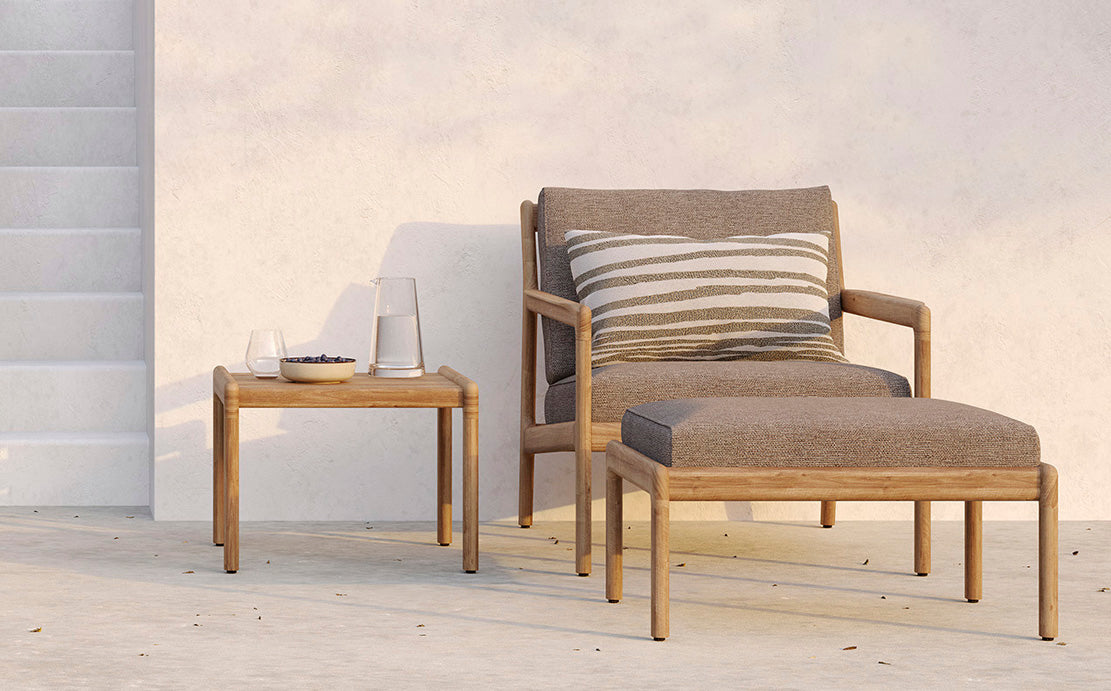 Jack Outdoor Side Table by Ethnicraft, showing front view of teak side table with sofa in live shot.