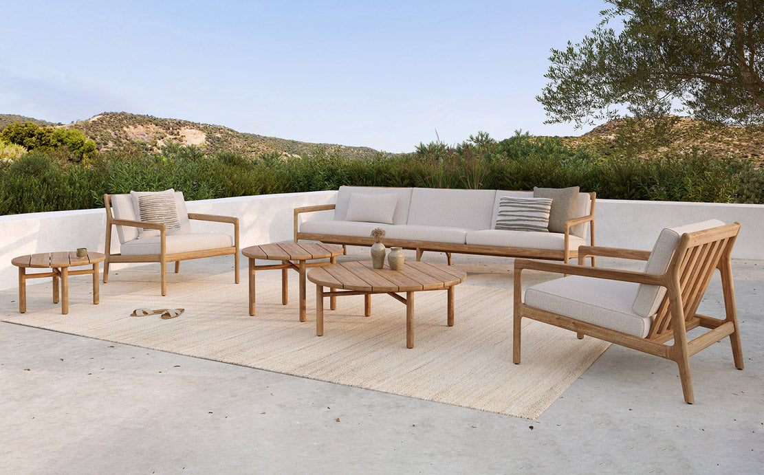 Quatro Outdoor Coffee Table by Ethnicraft, showing front view of teak outdoor coffee table with chairs in live shot.