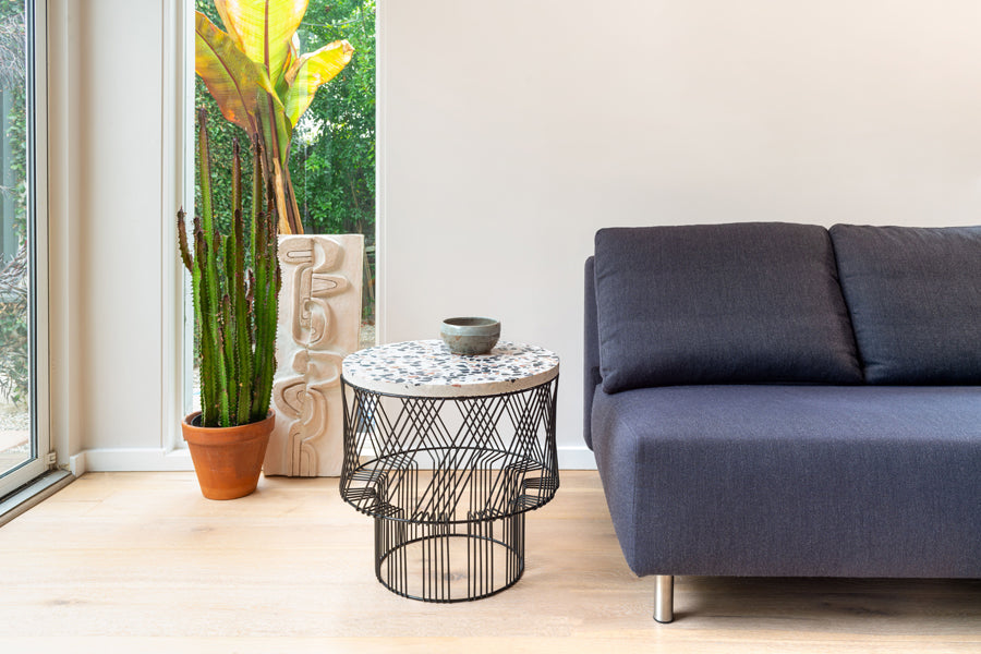 Terrazzo Side Table by Bend, showing terrazzo side table with sofa in live shot.